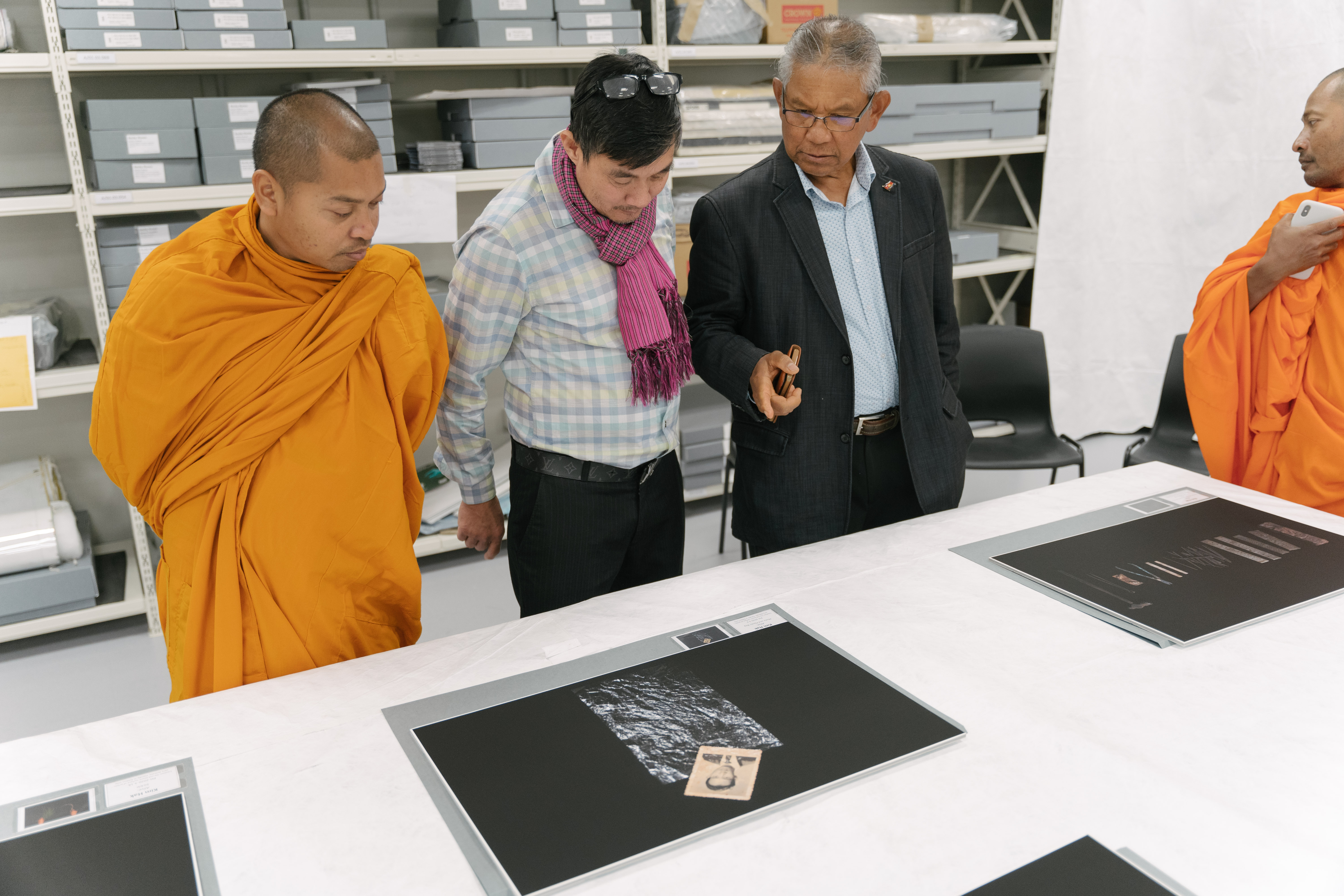 Two members of the Cambodian community and two monks view Kim Hal's photographs