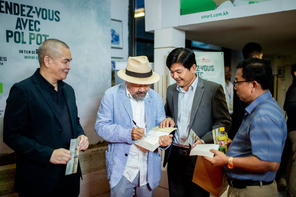 Mr. Rithy Panh autographing his book Elimination. Photo credit: Bophana Audiovisual Center.