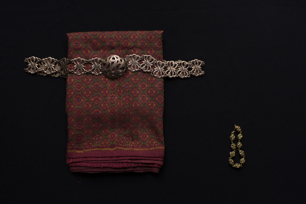Slider Image 14k rose gold belt, Khmer silk skirt and gold dangle bracelet (kantrum). Photograph by Kim Hak.　<br>14Kローズゴールドのベルト、クメールの絹のスカート、金のチェーン・ブレスレット（kantrum）
写真：キム・ハク