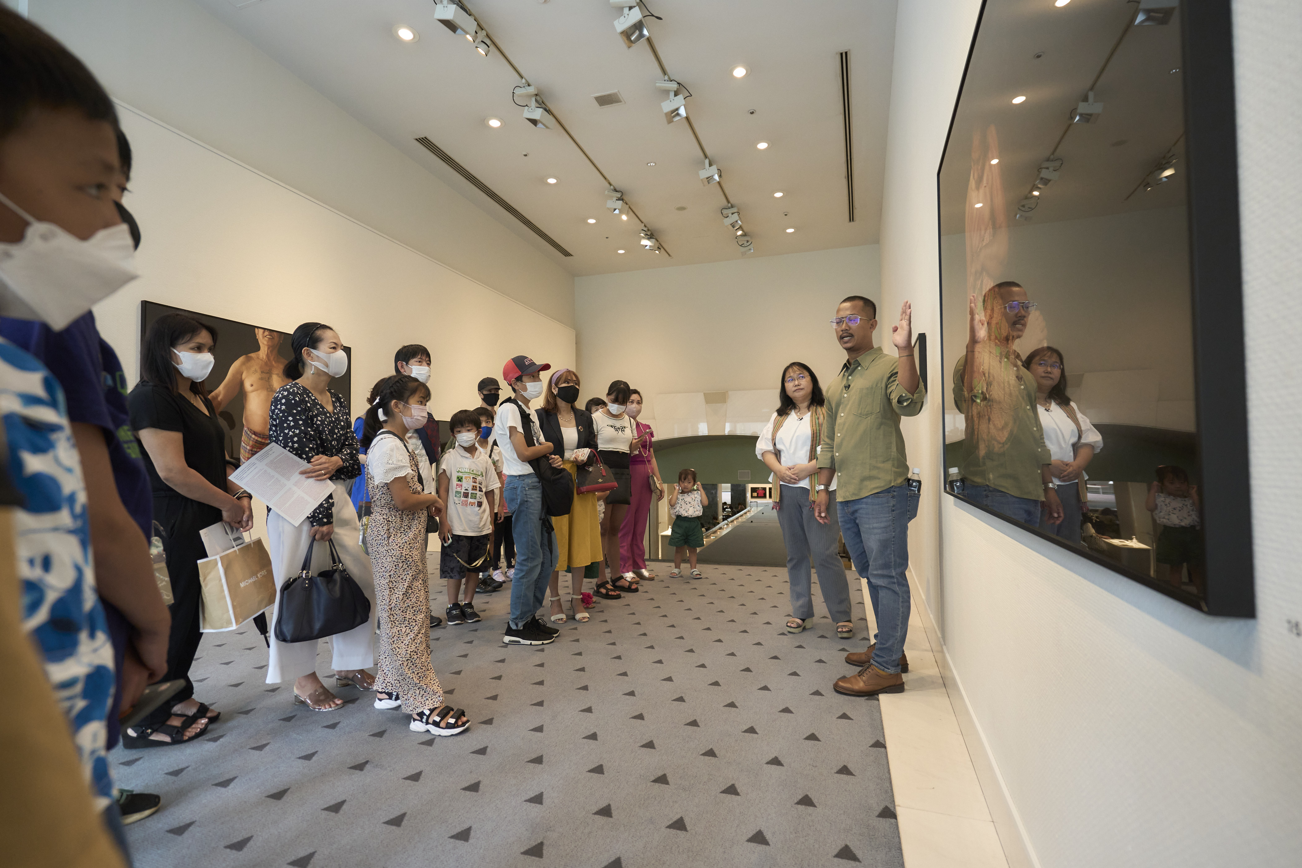 Slider Image Kim Hak leading a tour of his Alive IV exhibition in Tokyo. Photograph by Ryo Fujishima.
<br>東京の「生きるIV」展示会でガイドを務めるキム・ハク　写真：藤島 亮
