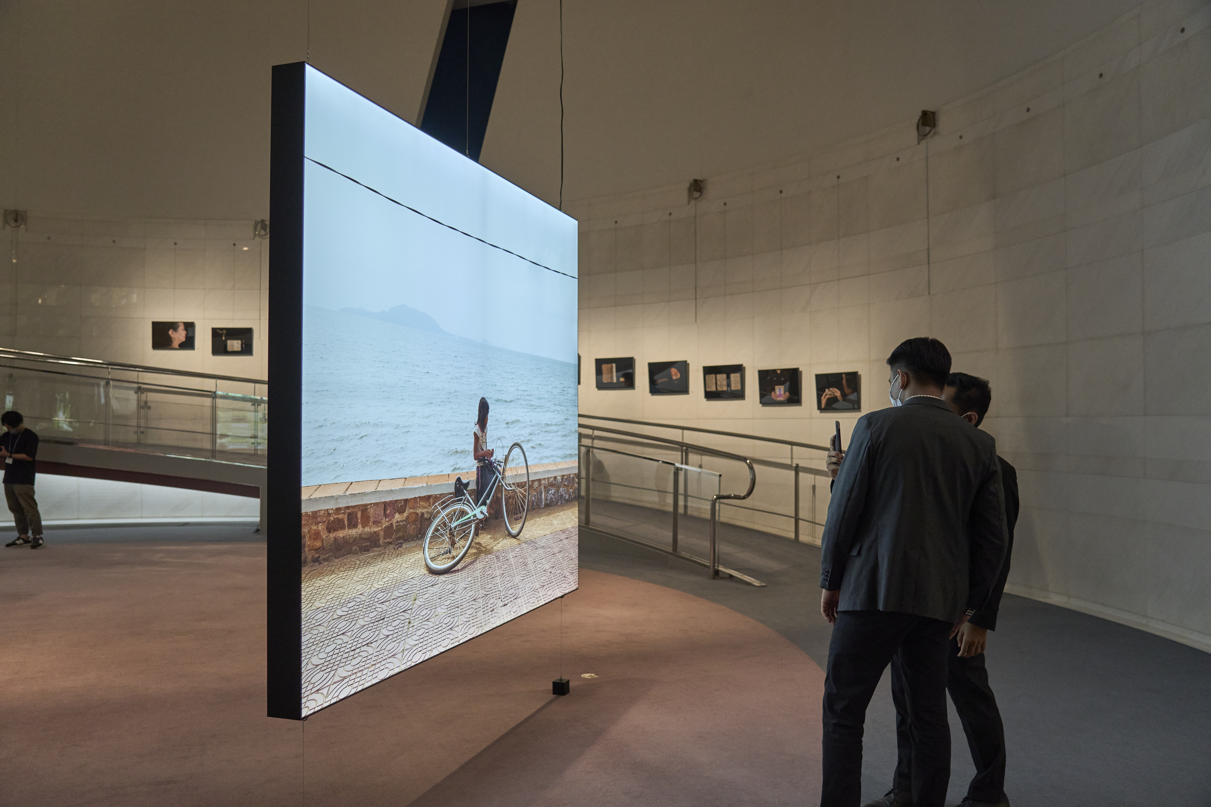 Slider Image Visitors look at Kim Hak's photography in Spiral Gallery.  Photography by Ryo Fujishima
<br>スパイラル・ギャラリーでキム・ハクの写真を観る来場者　写真：藤島 亮