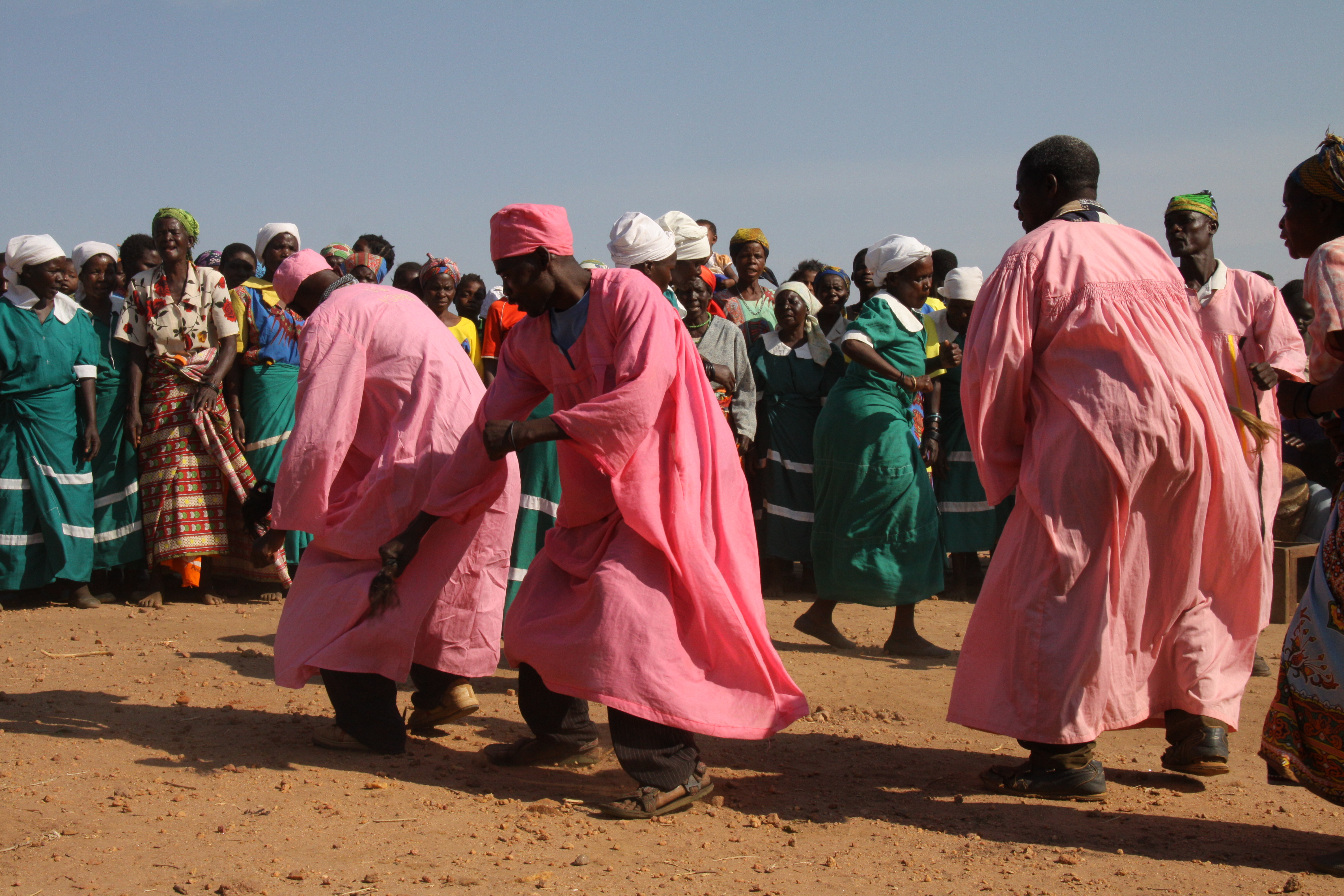 In Tsabango (Nanjiri Area) performers wear pink robes, surrounded by their fellow villagers. Photograph by Ingrid Ytre-Arne.