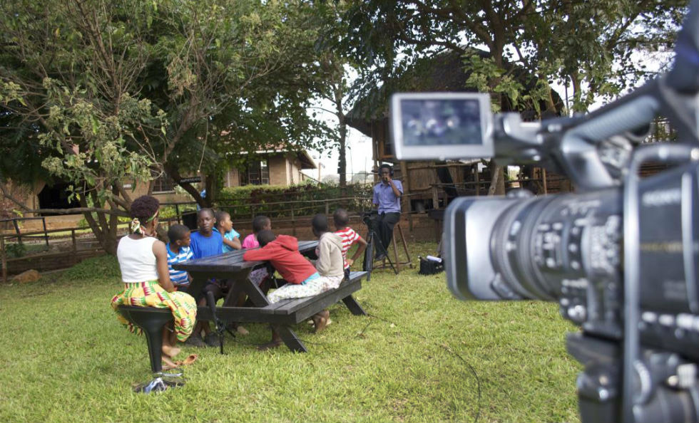 Slider Image An outdoor shoot featuring Linda Mpando with local children.
